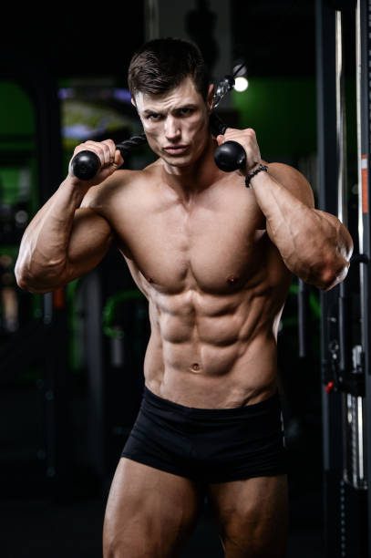 Strong and handsome athletic young man with muscles abs and biceps. Close-up of a power fitness man on diet